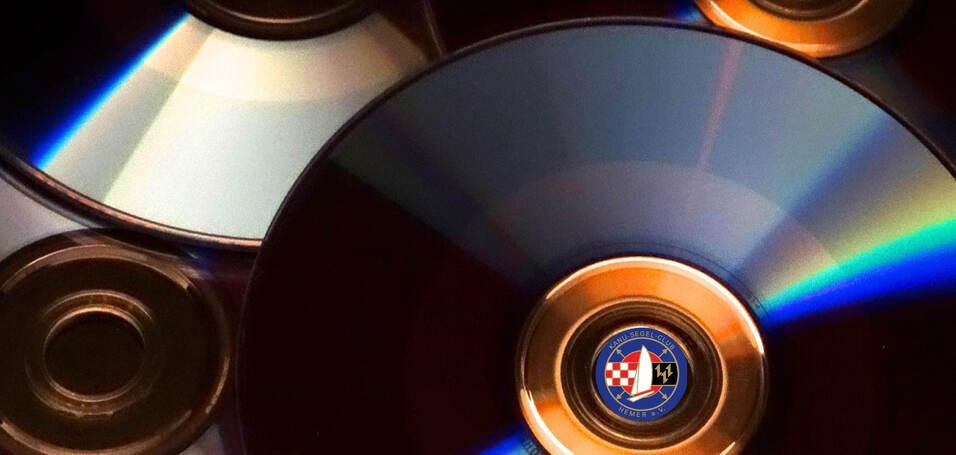 Nahaufnahme mehrerer CDs mit gl&auml;nzenden Oberfl&auml;chen und runden goldenen R&auml;ndern auf hellem Hintergrund.